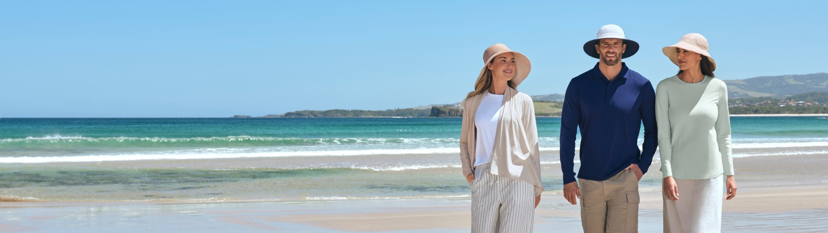 An image of three people walking on the beach in Solbari UPF 50+ sun protective clothing.