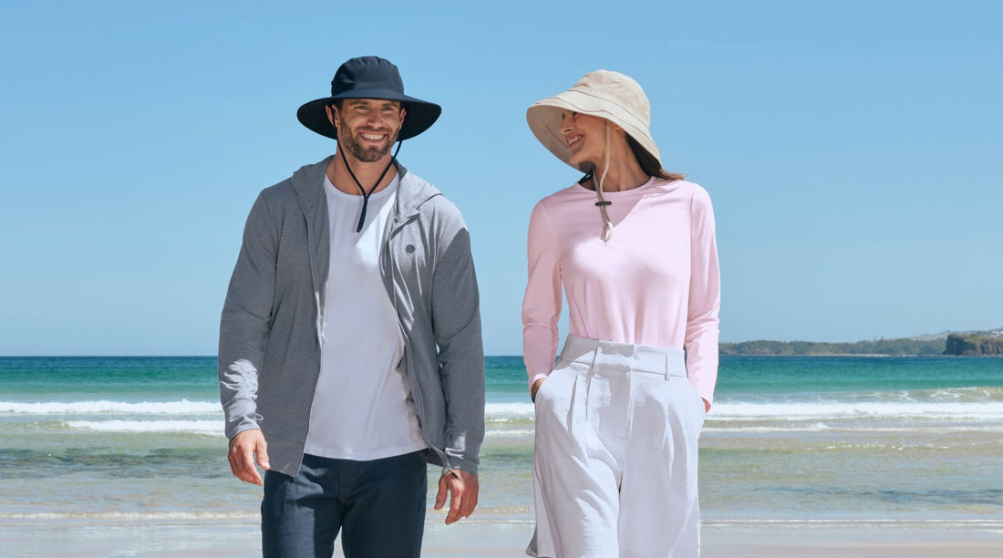 A Man and a woman on a beach wearing Solbari UPF 50+ sun hats and sun protective clothing.