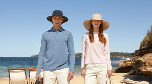 A woman and a man standing on a beach wearing Solbari sun hats and UPF 50+ clothing.