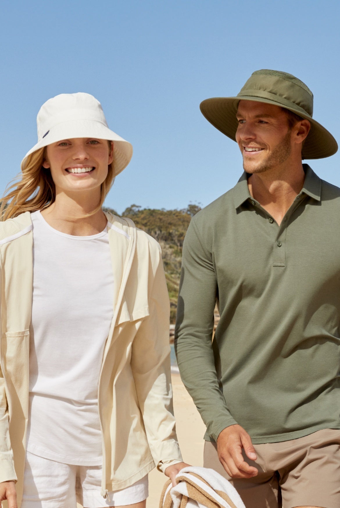 A man and woman wearing Solbari sun protective hats and clothing with a clear sky behind them