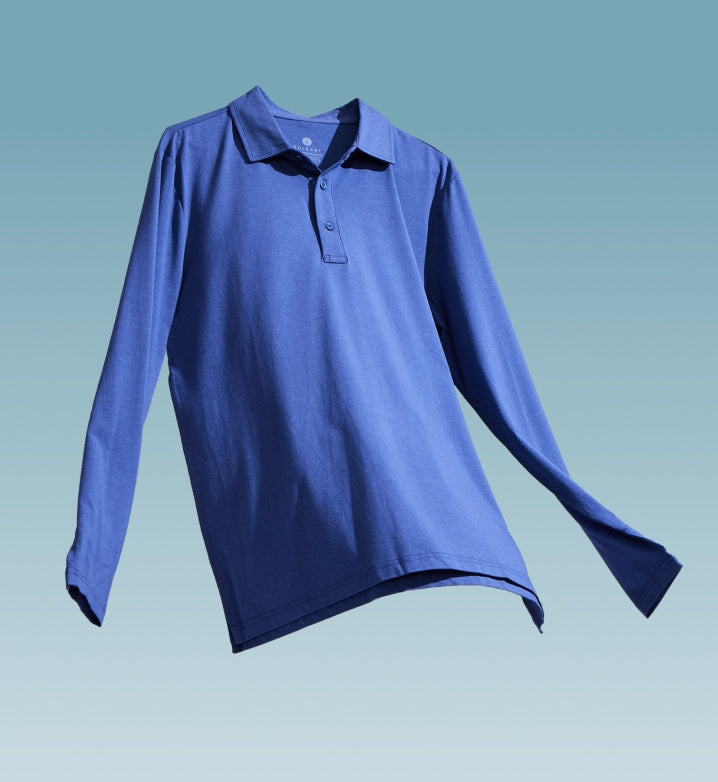 A blue long sleeve polo shirt  floating on a light blue background.