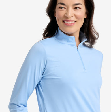 Woman in a blue top with a white background.