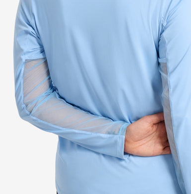Someone wearing a blue top, close-up view of sleeve, on a white background.
