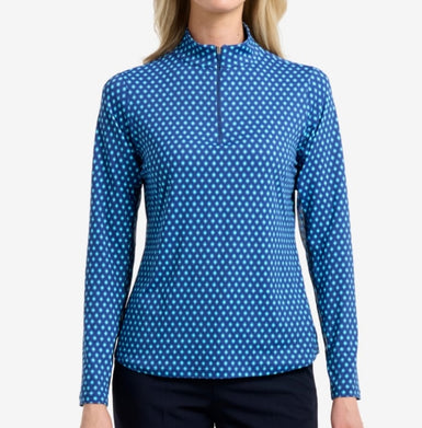 A woman wearing a blue printed diamond print top with long sleeves.
