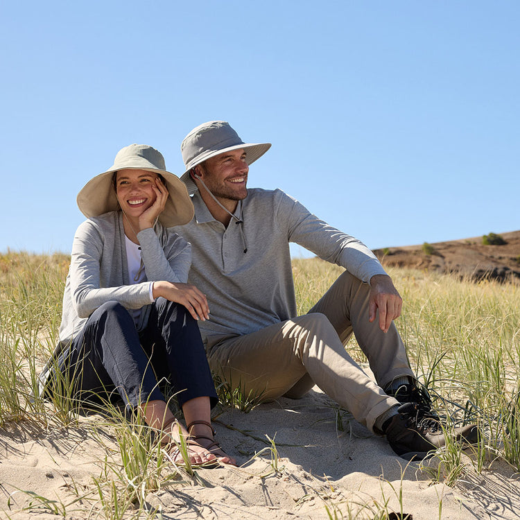 A couple sitting in the sun wearing Solbari sun hats and clothing.