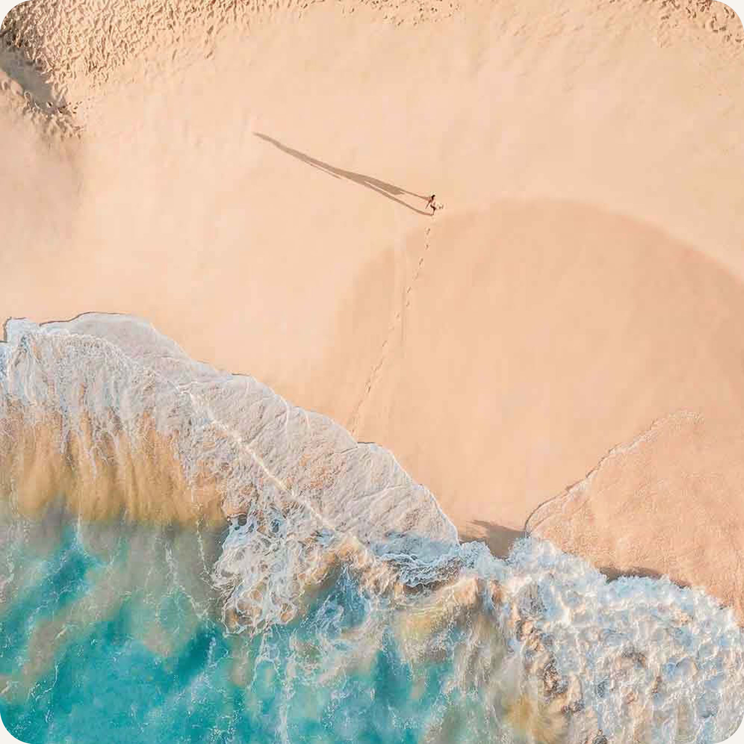 a beach and a person far away walking along it