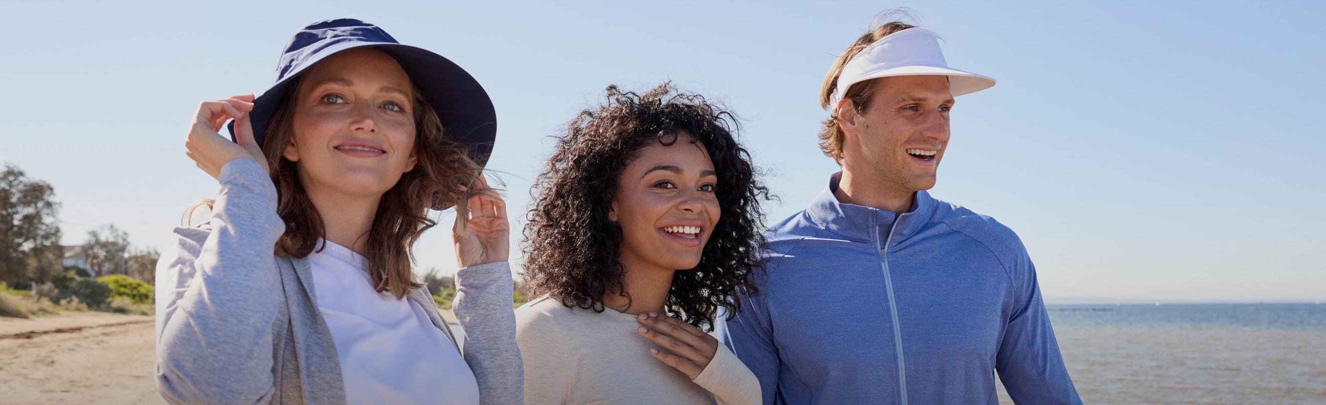 Three people standing in the sun on a beach wearing Solbari.